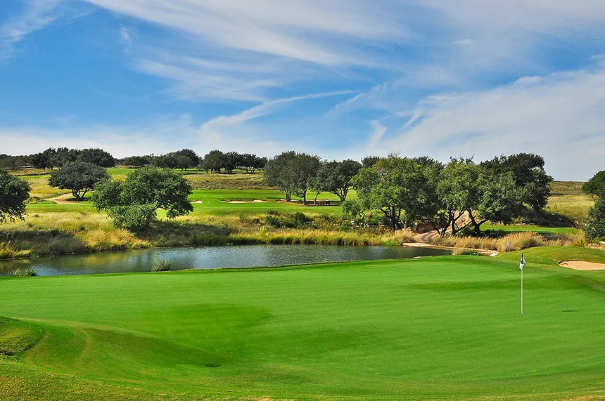 Spanish Oaks golf course fairway with rolling Hill Country ridges and clear blue sky